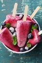 Homemade blueberry ice cream or popsicles decorated green mint leaves on teal rustic table, frozen fruit juice Royalty Free Stock Photo