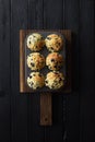 Homemade blueberry muffins on oak cutting board on black background with natural lighting top view Royalty Free Stock Photo