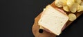 Homemade Bologna and Cheese Sandwich on a rustic wooden board on a black background, top view. Copy space
