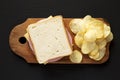 Homemade Bologna and Cheese Sandwich on a rustic wooden board on a black background, top view. Overhead, from above, flat lay