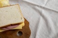 Homemade Bologna and Cheese Sandwich on a rustic wooden board on cloth, side view. Space for text