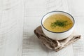 Homemade bone broth in a white bowl on a wooden background. The concept of healthy eating. Copy space