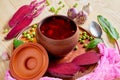 Homemade borscht with vegetables on the wooden background decorated with fresh sliced beet, garlic, basil and green peas