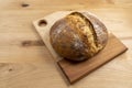 Homemade round loaf of freshly baked artisan sourdough bread on a wood cutting board Royalty Free Stock Photo