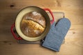 Homemade boule round loaf of freshly baked sourdough bread in a red Dutch oven Royalty Free Stock Photo