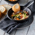 Homemade bowl of chicken vegetable and couscous soup served with bread.