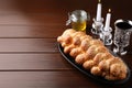 Homemade braided bread with sesame seeds, goblet, honey and candles on wooden table, space for text. Traditional Shabbat challah Royalty Free Stock Photo