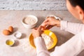 Homemade bread baking. closeup woman hands adding egg in flour, dough preparation in bright kitchen with marble countertop Royalty Free Stock Photo