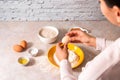 Homemade bread baking. closeup woman hands adding egg in flour, dough preparation in bright kitchen with marble countertop Royalty Free Stock Photo