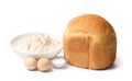 Homemade bread cooked in a bread machine and ingredients for baking on a white background Royalty Free Stock Photo