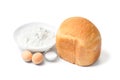 Homemade bread cooked in a bread machine and ingredients for baking on a white background Royalty Free Stock Photo