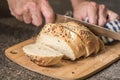 Homemade bread loaf with everything seasoning being sliced by hand