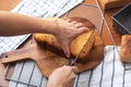 Homemade bread loaf with woman hand holding knife for slicing
