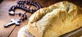 Homemade bread made in the Easter and Eucharist period, called Christ bread, religious symbol, with Bible and crucifix in the