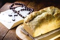 Homemade bread made in the Easter and Eucharist period, called Christ bread, religious symbol, with Bible and crucifix in the