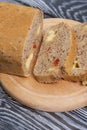 Homemade bread with tomatoes and cheese. Several slices are cut. They lie next to the loaf