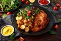 Homemade breaded pork schnitzel with roast potato and vegetables