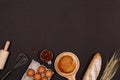 Homemade breads or bun, croissant and bakery ingredients, flour, almond nuts, hazelnuts, eggs on dark background, Bakery backgroun Royalty Free Stock Photo