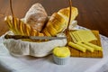 Homemade breads. different types of home made breads in basket with knife, wooden cutting board with cheese and porcelain ramekin