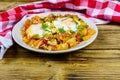 Homemade breakfast shakshuka with fried eggs, onion, bell pepper, tomatoes and dill on a wooden table. Jewish cuisine Royalty Free Stock Photo