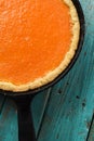 Homemade bright orange pumpkin pie in cast iron pan copyspace
