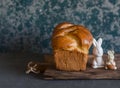 Homemade brioche and ceramic easter rabbits on a rustic cutting board. Front view. Royalty Free Stock Photo