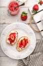 Homemade bruschetta with cottage cheese and strawberries for breakfast at white wooden background