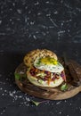Homemade burger with fried egg and coleslaw on a rustic wooden board on a dark background. Royalty Free Stock Photo