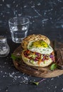 Homemade burger with fried egg and coleslaw on rustic wooden board on a dark stone background. Royalty Free Stock Photo