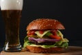 Homemade burger with grilled beef, cheese, onion, tomato, and green salad, sauce, with pickles and French fries, Royalty Free Stock Photo