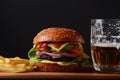 Homemade burger with grilled beef, cheese, onion, tomato, and green salad, sauce, with pickles and French fries, Royalty Free Stock Photo