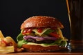 Homemade burger with grilled beef, cheese, onion, tomato, and green salad, sauce, with pickles and French fries Royalty Free Stock Photo