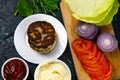 Homemade burger ingredients: tomatoes, purple onions, cabbage meatballs, white garlic and red sauce