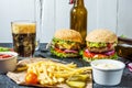 Homemade burgers with beef and fried potatoes and glass of cold dark beer on stone table Royalty Free Stock Photo