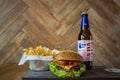 Homemade burgers with beef pear and cherry and french fried potatoes and bottle of cold beer on wooden table on a wood background Royalty Free Stock Photo