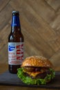 Homemade burgers with beef pear and cherry and french fried potatoes and bottle of cold beer on wooden table on a wood background Royalty Free Stock Photo