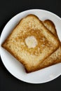 Homemade Buttered Toast on a white plate on a black background, top view. Flat lay, overhead, from above Royalty Free Stock Photo