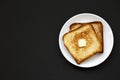 Homemade Buttered Toast on a white plate on a black background, top view. Flat lay, overhead, from above. Copy space Royalty Free Stock Photo