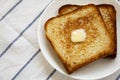 Homemade Buttered Toast on a white plate, close-up. Copy space