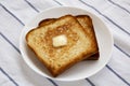 Homemade Buttered Toast on a white plate, side view