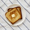 Homemade Buttered Toast on a white plate, top view. Flat lay, overhead, from above