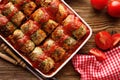 Homemade cabbage rolls stuffed with groats and mushrooms with tomato sauce in a baking dish on a wooden table Royalty Free Stock Photo