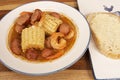 Homemade Cajun Shrimp Boil with Corn, New Potatoes, and Andouille Sausage with a Slice of Sourdough Bread Royalty Free Stock Photo