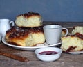 Homemade cake.Buns filled with jam, sprinkled with sesame and icing sugar, on an ancient wooden table, with ingredients and a Cup Royalty Free Stock Photo