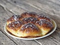 Homemade cake.Buns filled with jam, sprinkled with sesame seeds and icing sugar on a porcelain plate on an ancient wooden table Royalty Free Stock Photo