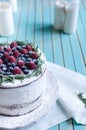 Homemade cake decorated berries on plate over wooden turquoise background