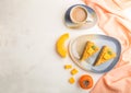 Homemade cake with persimmon and pumpkin and a cup of coffee on a white wooden background with orange textile. top view, copy Royalty Free Stock Photo