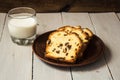 Homemade cake raisins and glass of milk on light wooden background