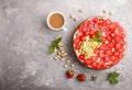 Homemade cake with yoghurt cream, strawberry and pistachio on a gray concrete background. top view