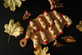 Horrible scary tasty witch Fingers cookies, wooden chopping Board, autumn maple leaves on black background.